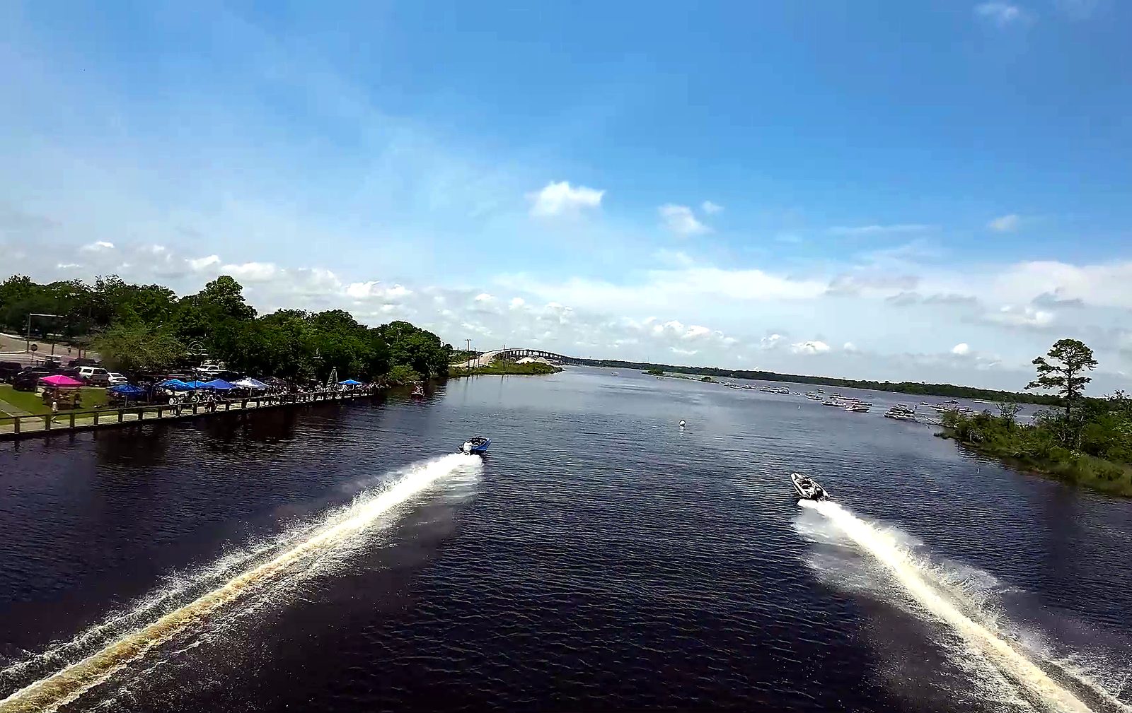 Aerial view of two drag boats racing down the Escatawpa with twin white wakes