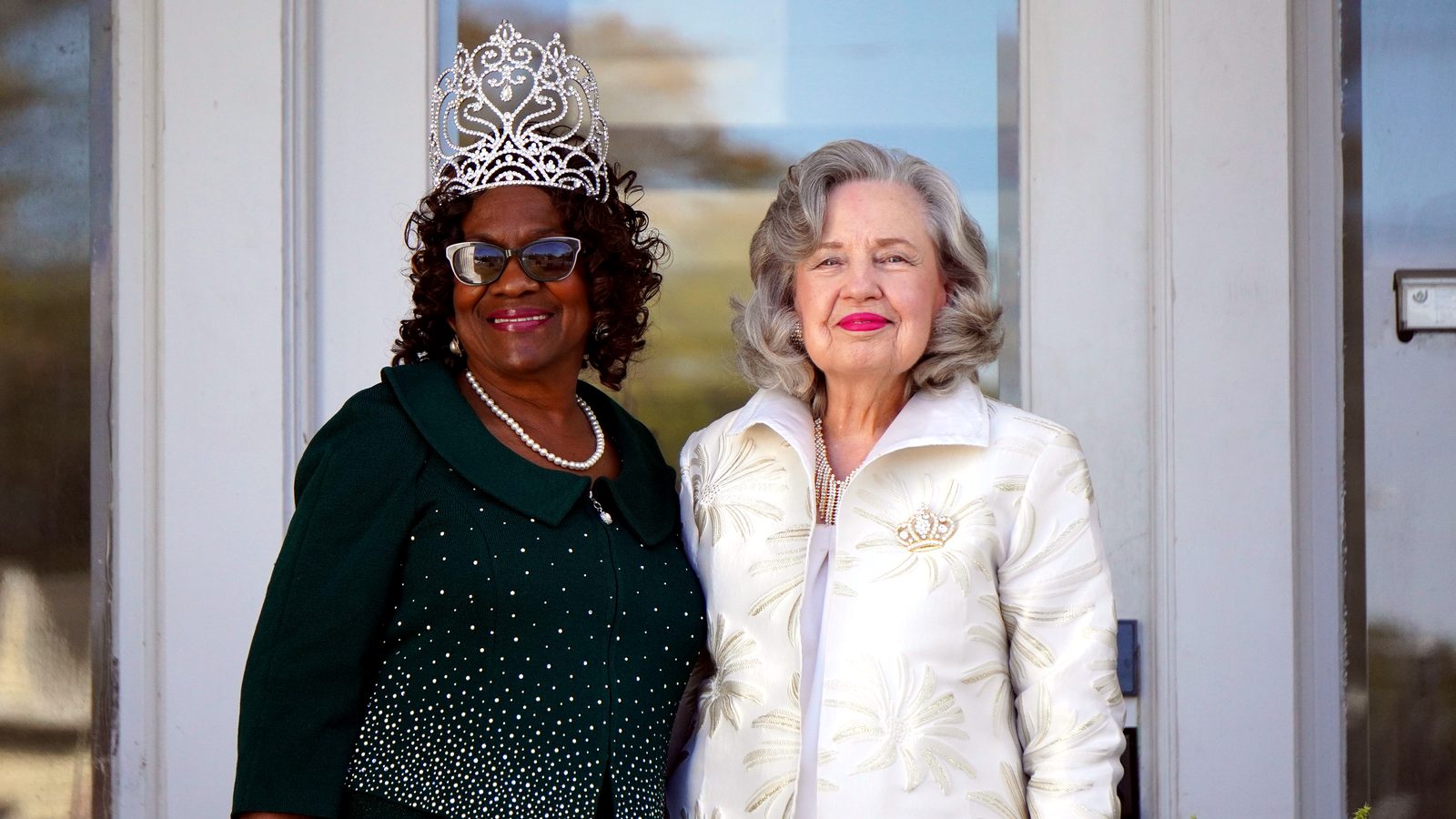 Two queens together, one wearing a silver crown